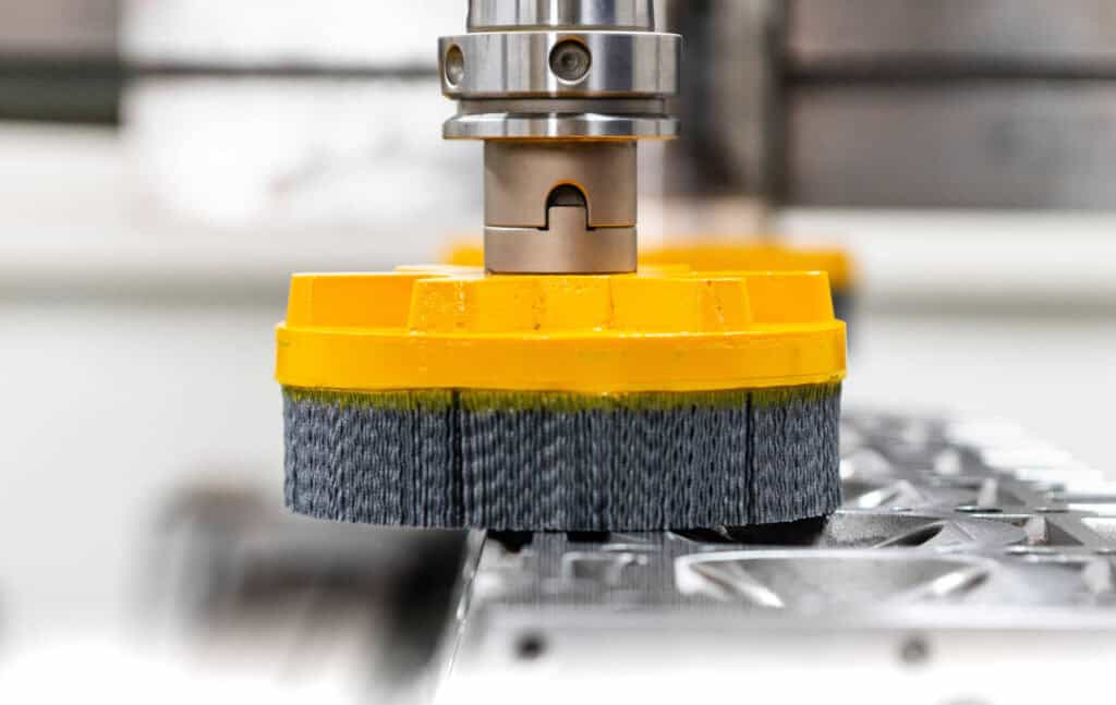 Spazzola ATB al lavoro su una testata motore. Scegliendo una grana abrasiva opportuna è possibile fornire un valore di finitura superficiale corretto per impedire trafilamenti della guarnizione, preservandone al tempo stesso l'integrità